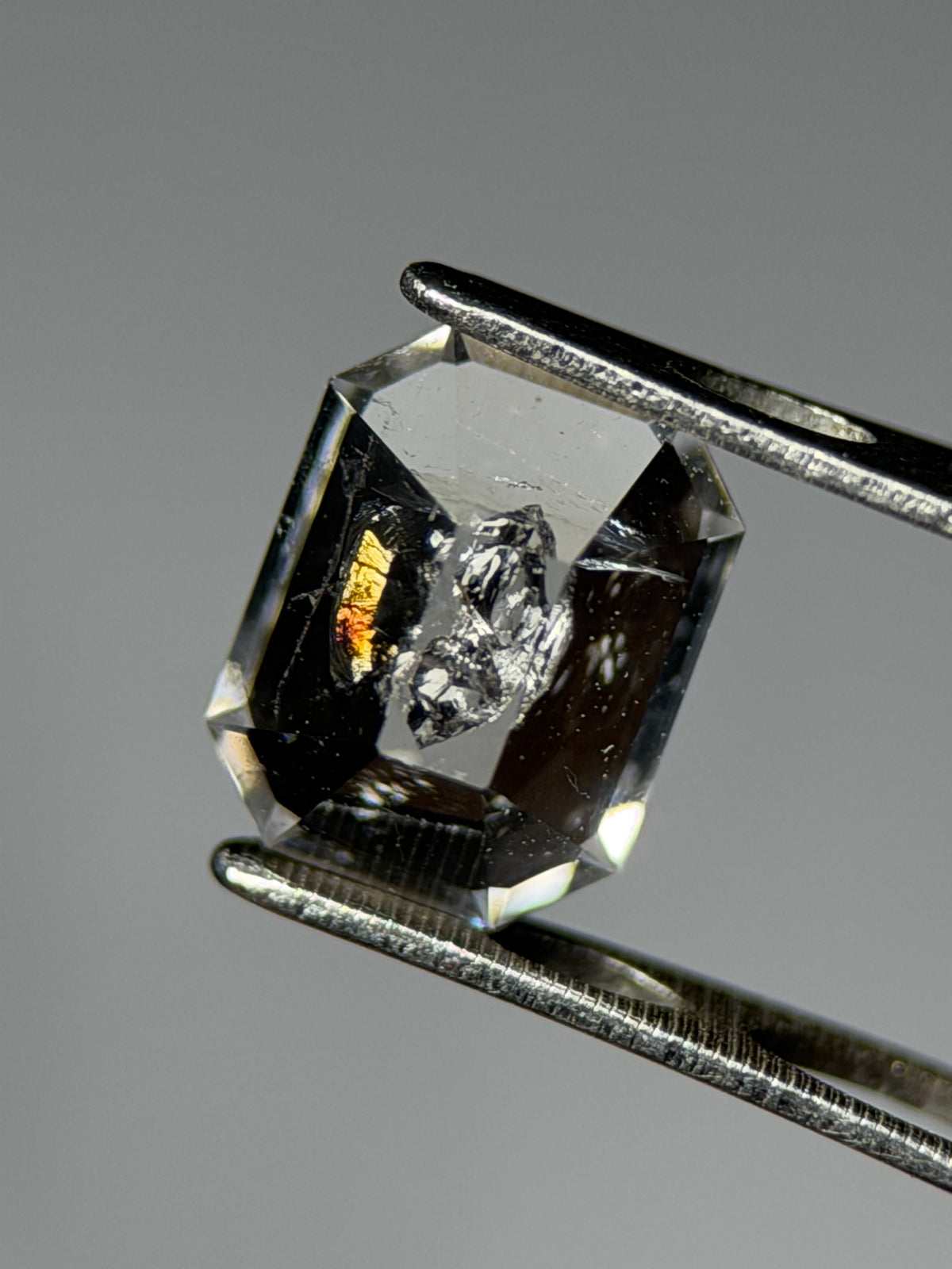 天然石油水晶 – 0.75 克拉八角形切割 (4.9 x 6.3 毫米) – 彩虹光暈與黑色礦物